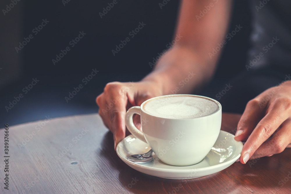 hands hold hot cup of coffee in the coffee shop. hands hold hot cup of coffee in the coffee shop.