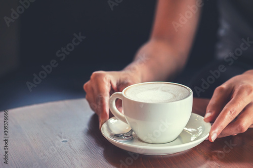 hands hold hot cup of coffee in the coffee shop.