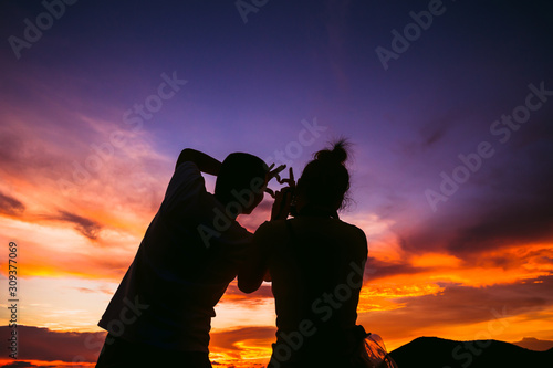silhouette couple standing together with sunset.