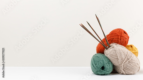 Fotografija Red, green, yellow and beige pastel colored clews of yarn
