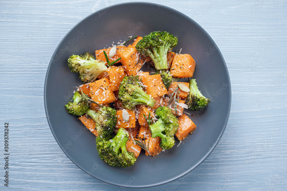 Salad in a round plate of baked broccoli and pumpkin. sprinkled with parmesan. Salad in a round plate of baked broccoli and pumpkin. sprinkled with parmesan.