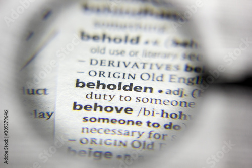 The word or phrase beholden in a dictionary.