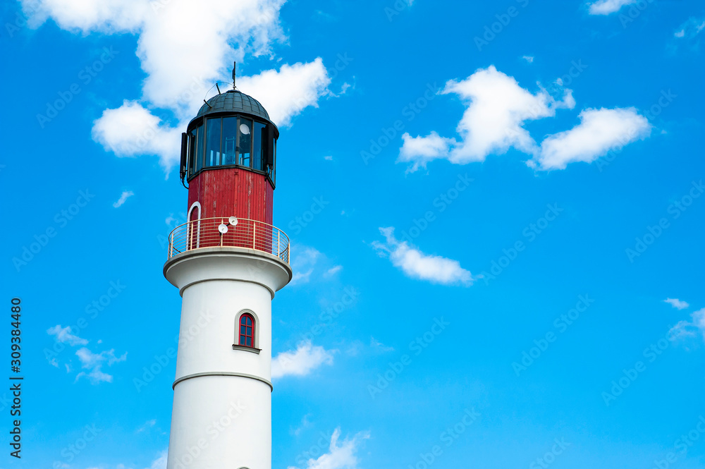 White lighthouse against blue sky on a summer day