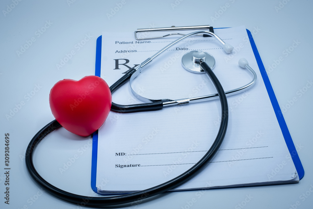 Red heart medical stethoscope and black pen Put on the doctor's charging plate.Health examination concept Health insurance. Medical health. Taking care of yourself as ordered by a doctor.Close up. Red heart medical stethoscope and black pen Put on the doctor's charging plate.Health examination concept Health insurance. Medical health. Taking care of yourself as ordered by a doctor.Close up.