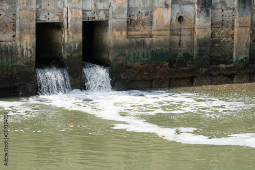 dirty water flow to sewer from city, waste water flows from a pipe, Sewage pipe polluting water