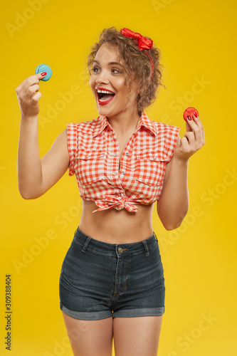 Beautiful smiling woman choosing between two macaroons