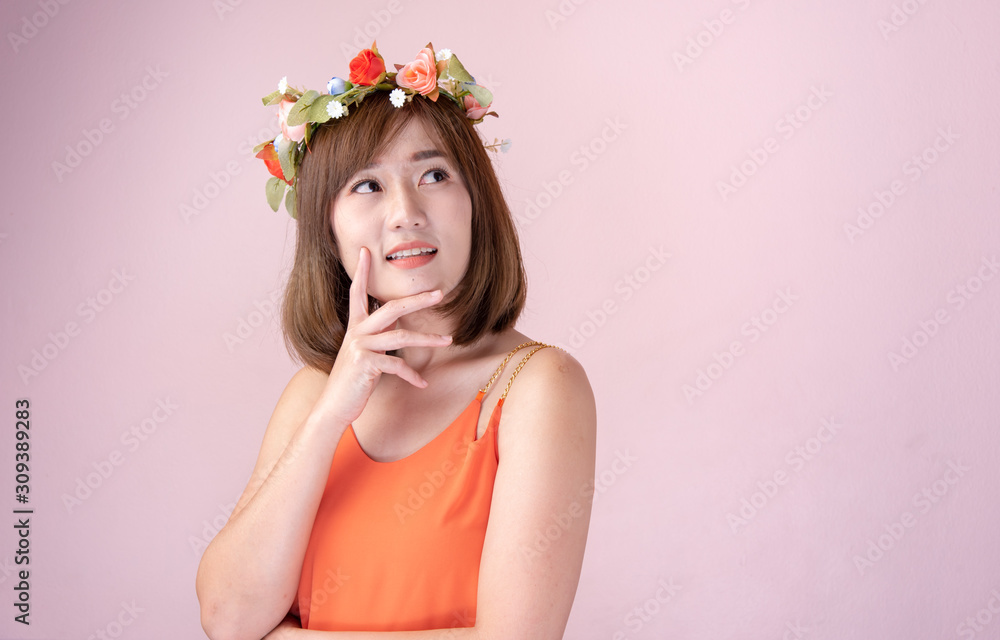 Asian woman wearing a crown of flowers with beautiful bouquet of flowers on a nice day with a pink background,Fashion model having fun. Asian woman wearing a crown of flowers with beautiful bouquet of flowers on a nice day with a pink background,Fashion model having fun.