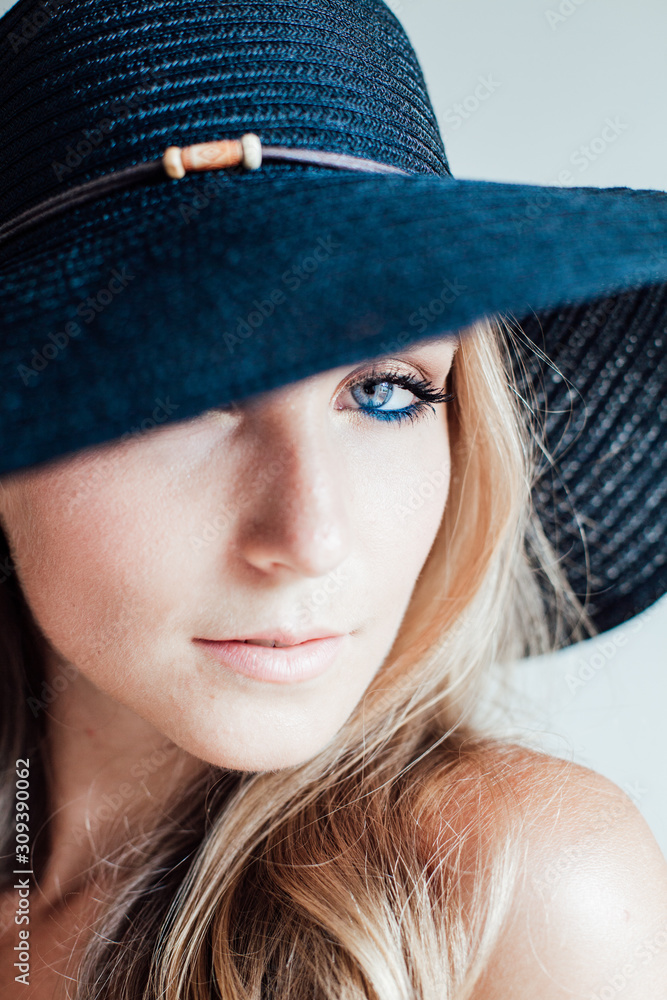 portrait of a beautiful fashionable blonde woman in a black hat with fields portrait of a beautiful fashionable blonde woman in a black hat with fields