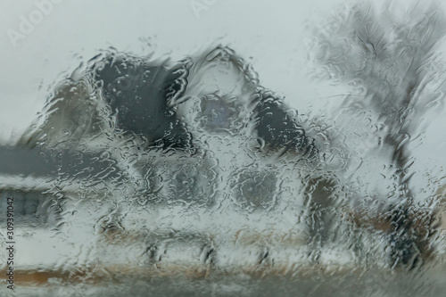 Dwelling house through wet window, autumn day. texture