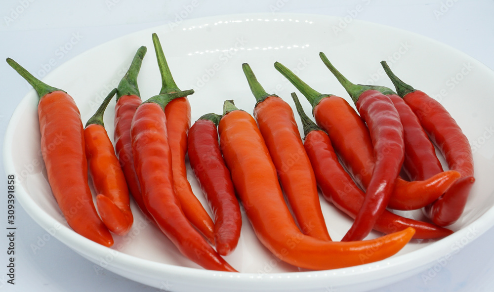 organic red chili pepper in dish isolated on white background organic red chili pepper in dish isolated on white background
