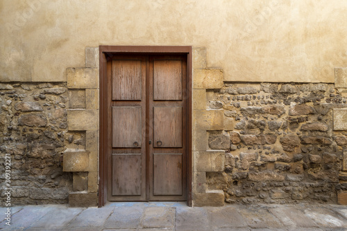 Grunge wooden aged door on grunge stone bricks wall, Medieval Cairo, Egypt photo