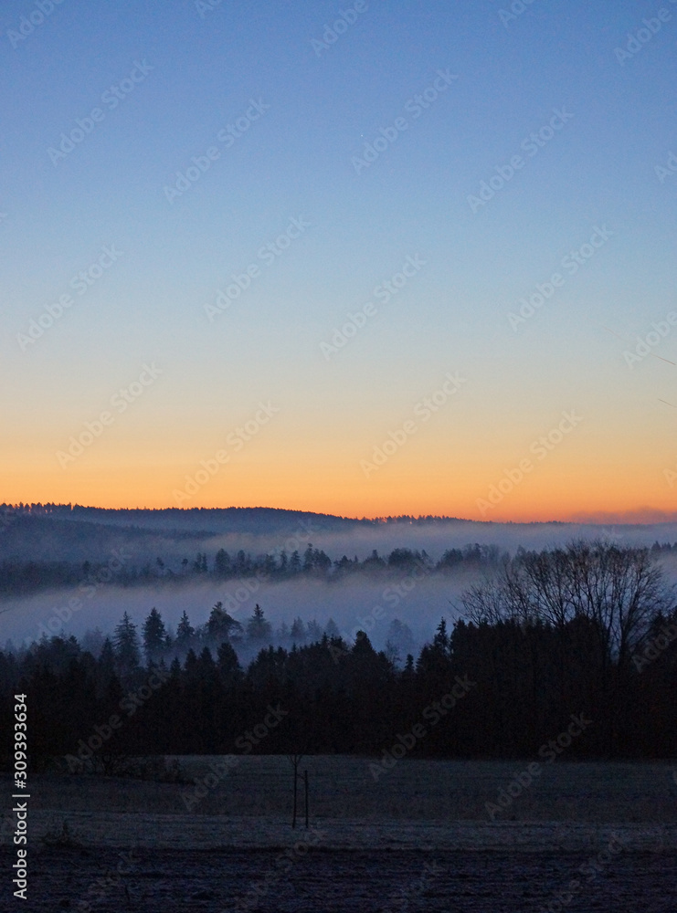 Morgenrot bei wolkenlosem Himmel über Talnebeln im Schwarzwald