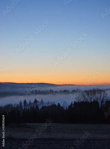 Morgenrot bei wolkenlosem Himmel über Talnebeln im Schwarzwald