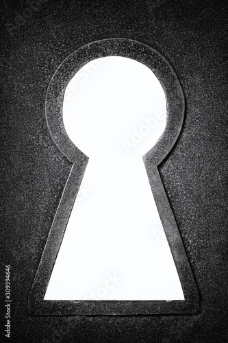 Black and white photo of a rusty metallic keyhole isolated on the white background photo