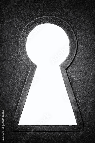 Black and white photo of a rusty metallic keyhole isolated on the white background