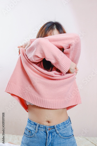 Murais de parede Teen girl  is removing the sweater at home.