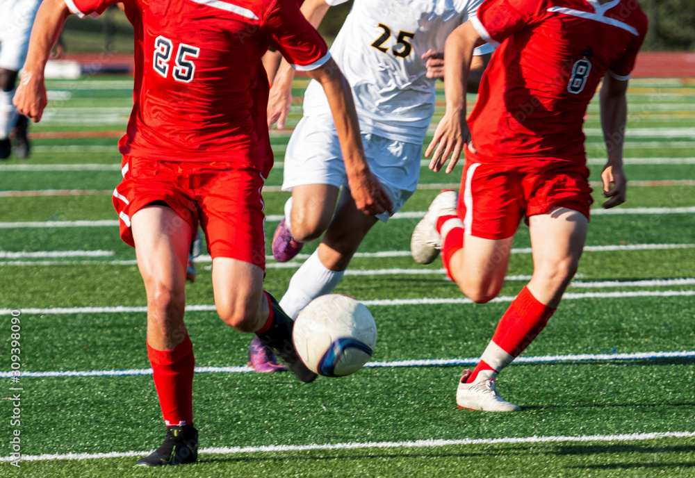 High school soccer team on a breakaway with both teams running down the field High school soccer team on a breakaway with both teams running down the field