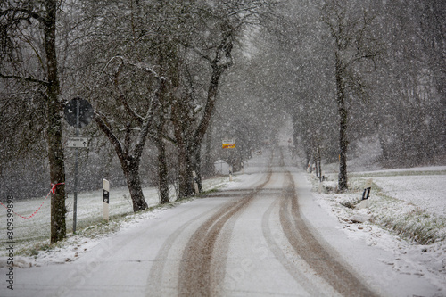 A lonely bavarian road as heavy snow falls on a winter's afternoon