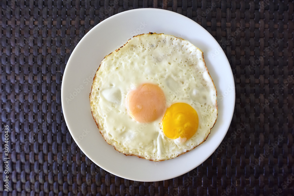 Top view of fried egg with white dish on the table background. Top view of fried egg with white dish on the table background.