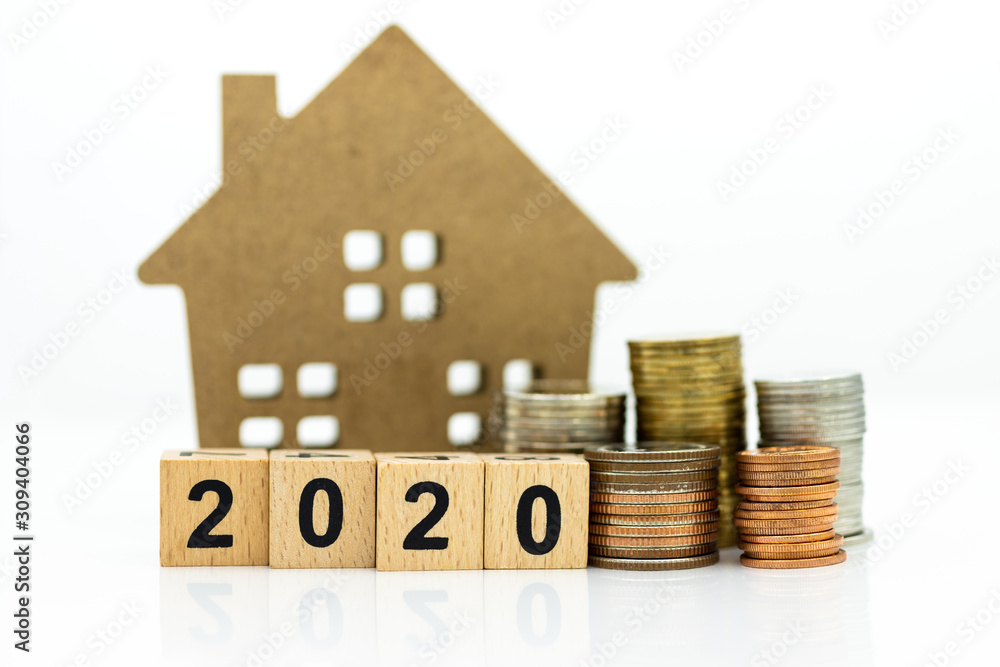 Wooden home with stack of coins, block 2020. Image use for background money, financial, insurance concept. Wooden home with stack of coins, block 2020. Image use for background money, financial, insurance concept.