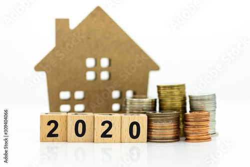 Wooden home with stack of coins, block 2020. Image use for background money, financial, insurance concept.