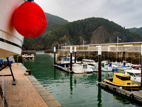 Boat with red buoy in the dock of Arminza, Basque Country photo