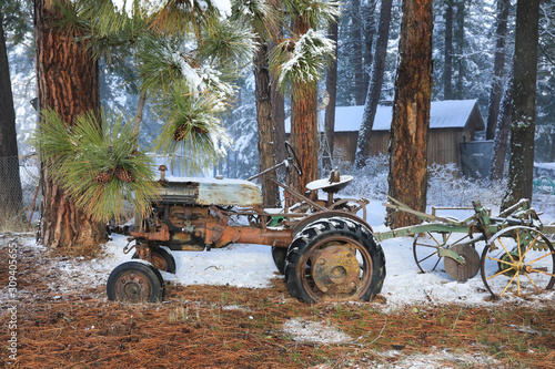 Winter old American Country landscape with rustic houses, cars and fences covered in snow. photo