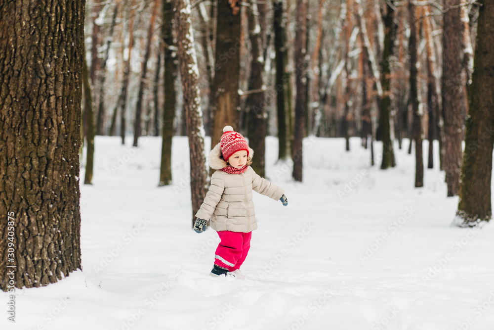child girl walking in forest.wintertime with snow