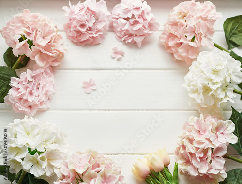 Frame made of pink and beige hydrangea  branches on white background. Flat lay  top view. Wedding. Mother s Day or Easter Greeting Card Template. Space for text. Flowers on white wooden background