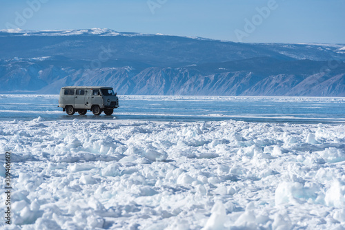 Baikal lake, Heavy 4wd car used to take tourists to travel on the ice around Baikal lake wtih blue sky sunlight background, Russia.