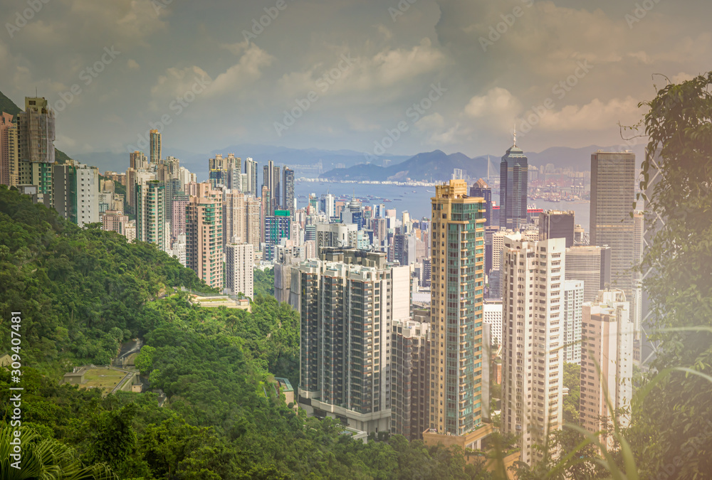 Fototapeta premium View of the sunrise over Victoria Harbor from the peak of Victoria Peak,Below, filled with a lot of tall buildings stacked together.
