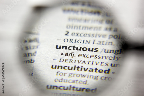 The word or phrase Unctuous in a dictionary. photo