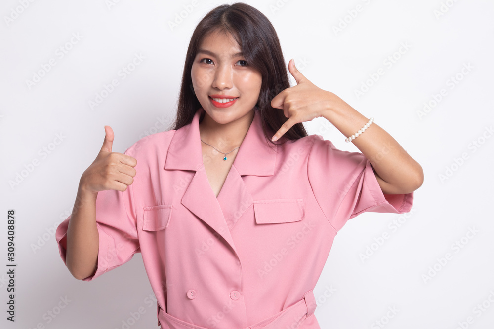 Young Asian woman thumbs up show with phone gesture. Young Asian woman thumbs up show with phone gesture.
