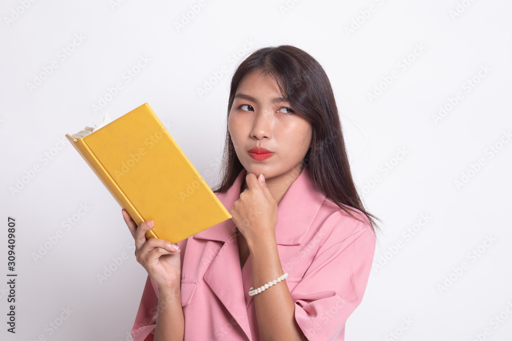 Young Asian woman with a book is thinking. Young Asian woman with a book is thinking.
