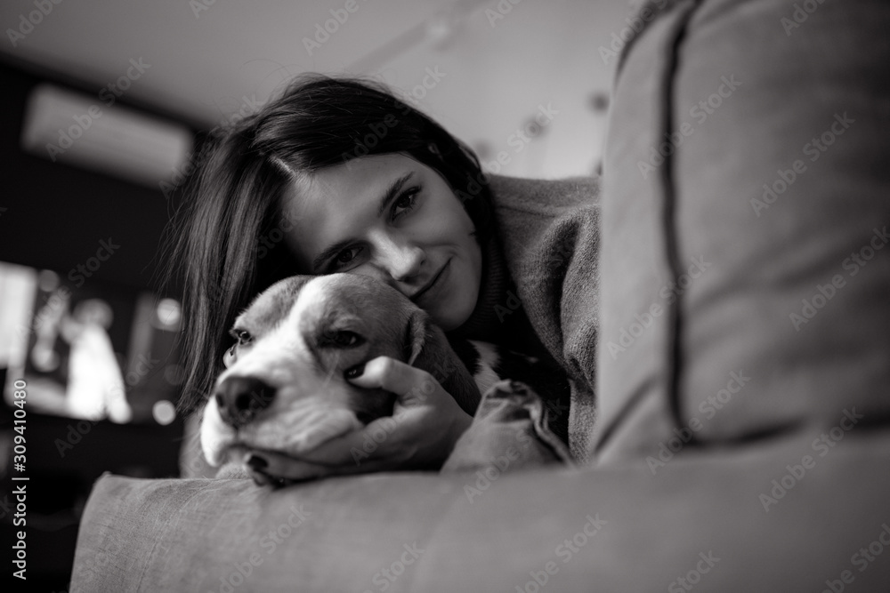 A woman lies next to a dog and hugs him. A woman lies next to a dog and hugs him.