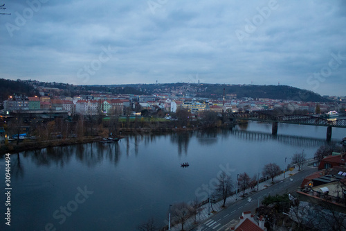  Winter panorama from Vysehrad Castle to the evening city of Prague, residential areas, the Vltava River, moorings with boats and boats and city transport.