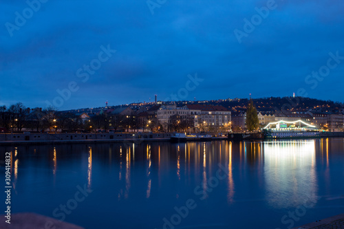  Night city landscape and panorama in the bright evening lights of the Czech capital Prague overlooking the Vltava River. © Olena