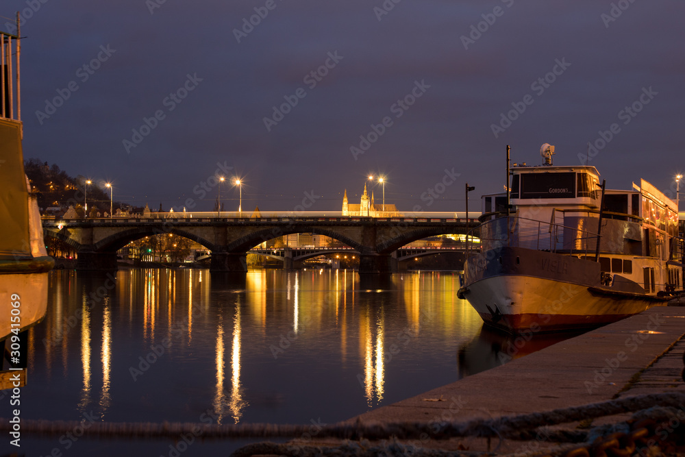  Night city landscape and panorama in the bright evening lights of the Czech capital Prague overlooking the Vltava River.