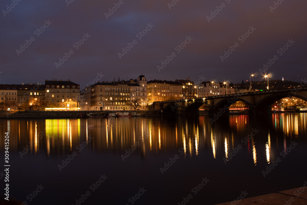 Night city landscape and panorama in the bright evening lights of the Czech capital Prague overlooking the Vltava River.