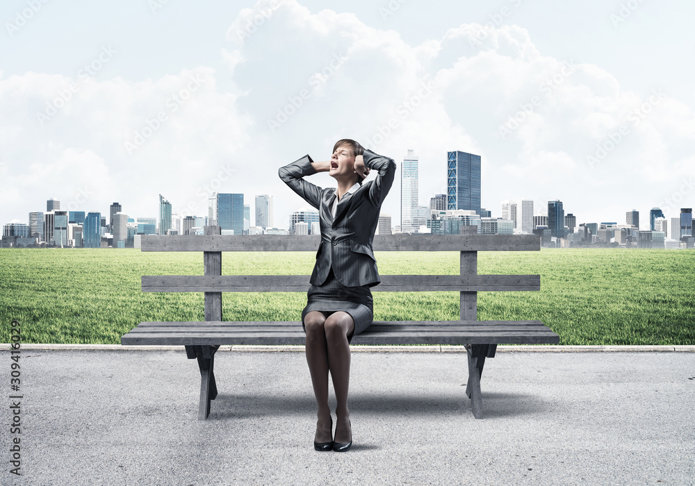 Stressful woman sitting on wooden bench Stressful woman sitting on wooden bench