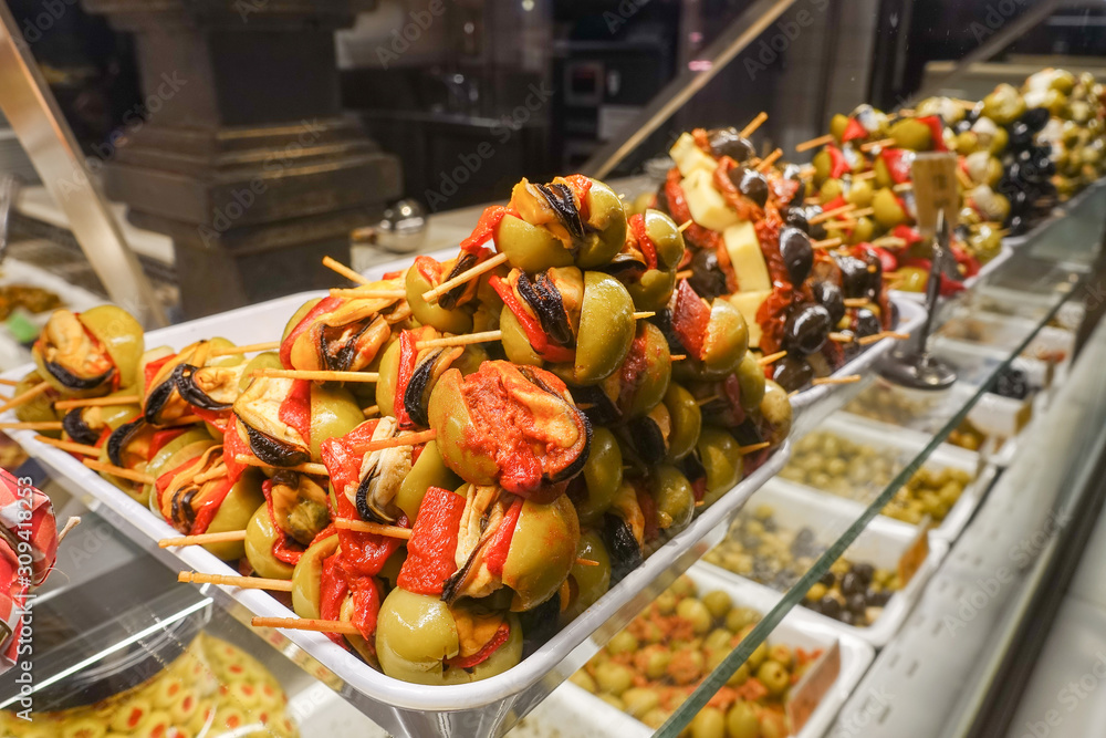 Obraz premium Stuffed green olives on wooden sticks on sale at Mercado San Miguel market in Madrid, Spain