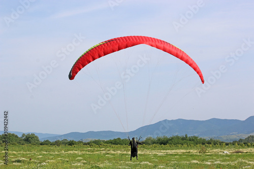 Paraglider landing in a meadow