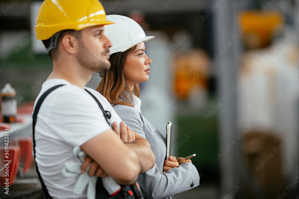 Successful man and woman discussing work. Architect team in factory. 