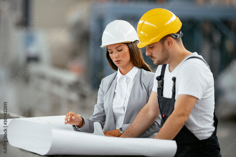 Successful man and woman discussing work. Architect team in factory. Successful man and woman discussing work. Architect team in factory.
