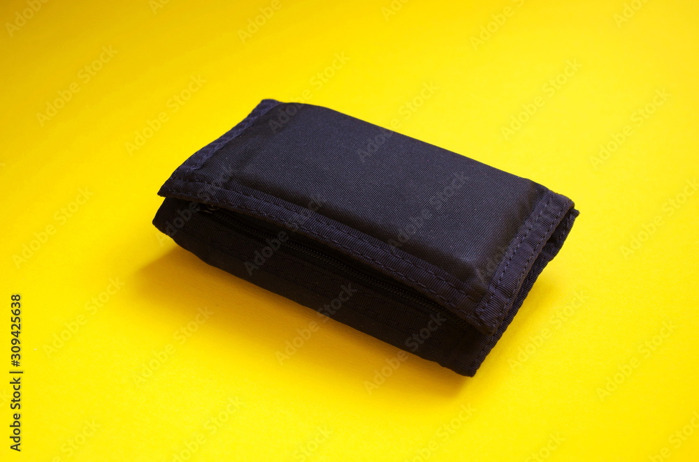 Black sports men's wallet on yellow background. Place for text. Financial situation concept. Black sports men's wallet on yellow background. Place for text. Financial situation concept.