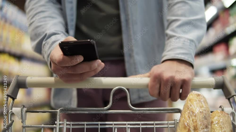 Cropped close up footage of a young man pushing trolley cart against ...
