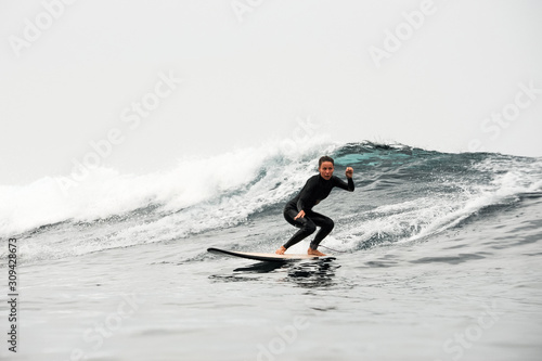 Girl surfing the wave in the ocean