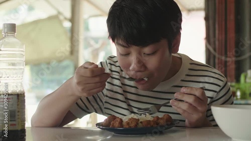 Cute Thai boy eating fried rice food. Asian boy eating and looking camera with smile face.