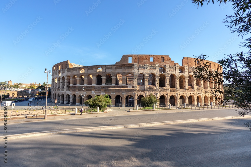 Historic monument, Colosseum in spring with walking tourists in the Italian city of Rome.