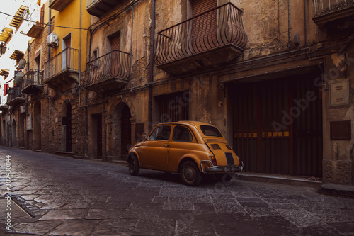Old orange vintage car in the street of the Ortigia island in Sicily, Italy © Andrii Shnaider